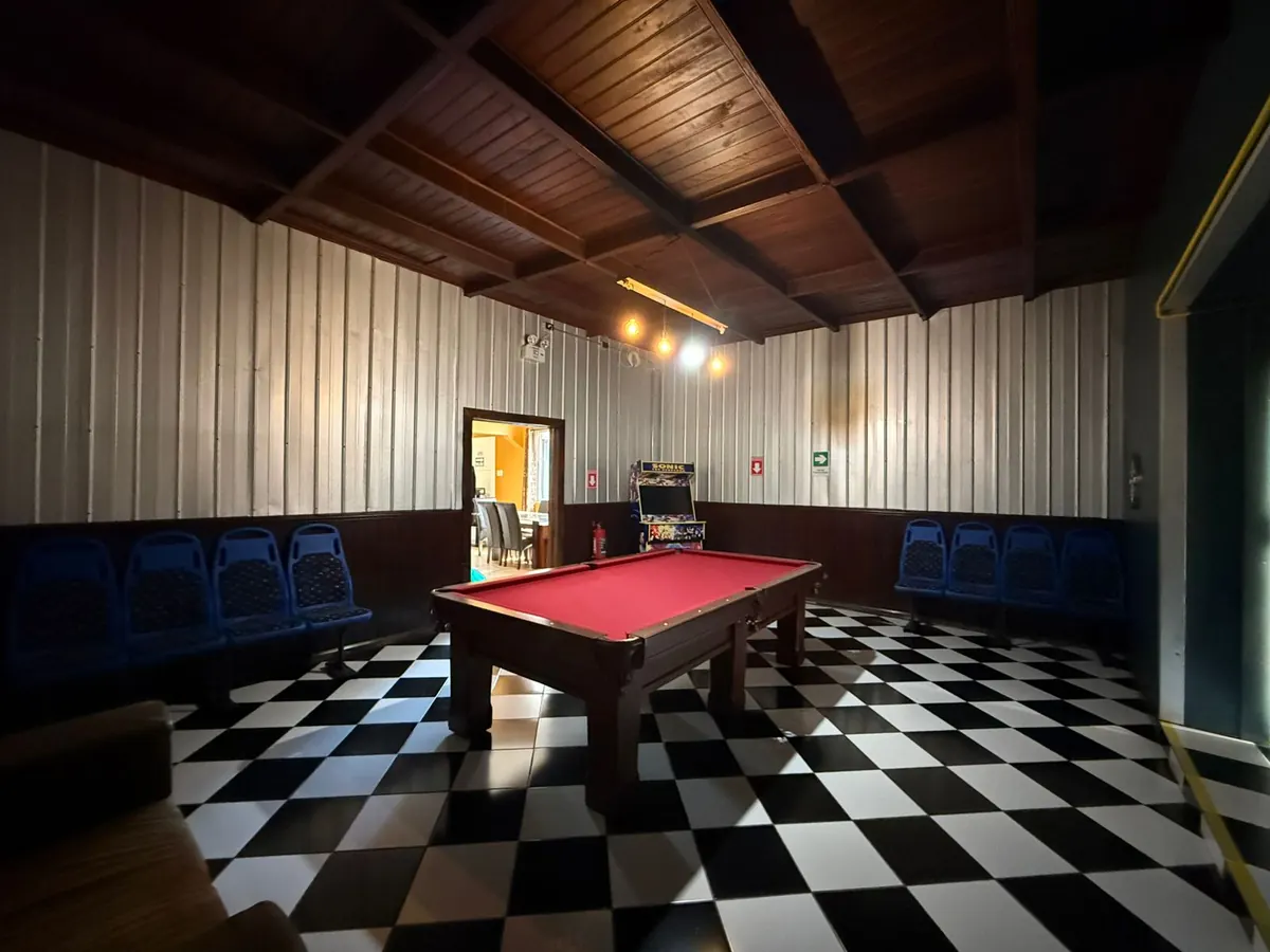 Sala de recreo con mesa de pool y máquina arcade